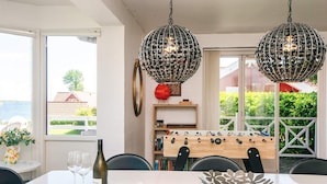 A dining area with a table, chairs, a wine bottle, glasses, a decorative bowl, and a foosball table. - 4 Star Holiday Home in Haderslev (Haderslev)