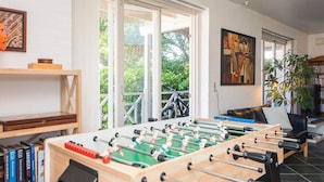 A room with a foosball table, a bookshelf, a sofa, and a painting on the wall. - 4 Star Holiday Home in Haderslev (Haderslev)