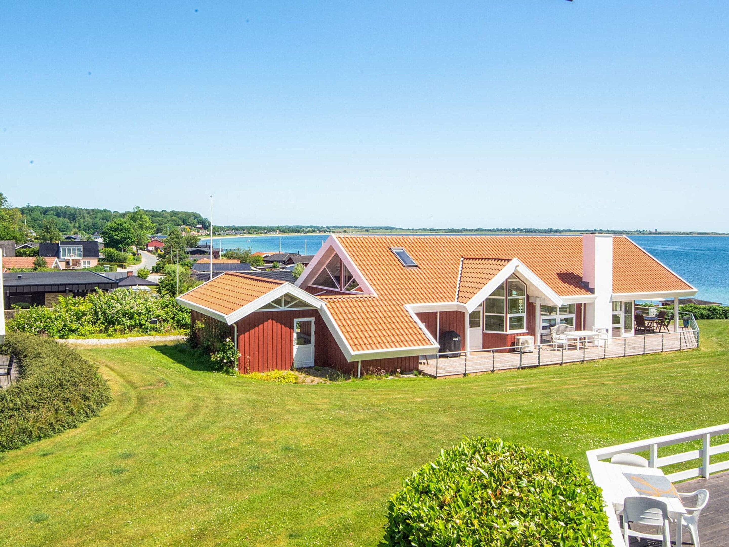 Una casa frente al mar con una terraza amplia, piscina y vistas al océano.