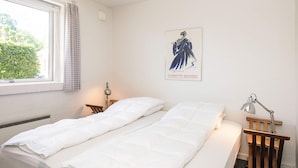 A room with a bed, a desk, a chair, a lamp, and a poster on the wall. - 4 Star Holiday Home in Haderslev (Haderslev)