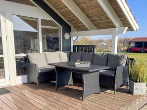 Une terrasse extérieure avec un canapé, une table et des chaises.