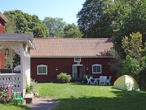 A red brick house with a tiled roof, a porch, and a tent in the yard. - 8 Person Holiday Home in Vimmerby (Vimmerby)