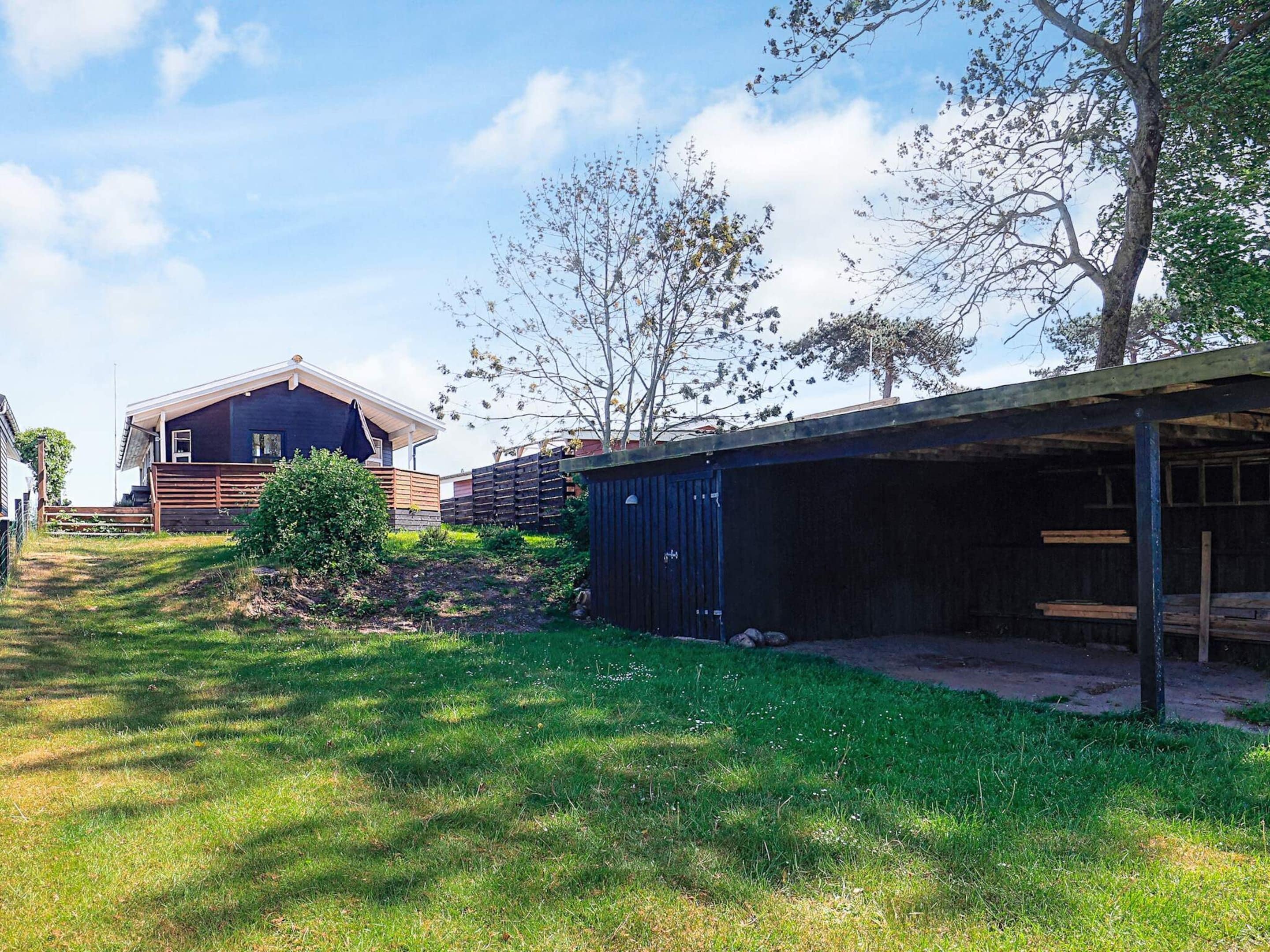 A residential property with a detached house, a covered garage, and a well-maintained lawn.