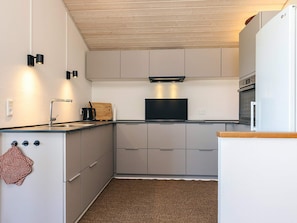 A compact kitchen with a built-in oven, a microwave, and a coffee maker.
