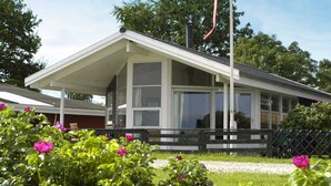 En byggnad med en vit fasad, stora fönster och en flaggstång.