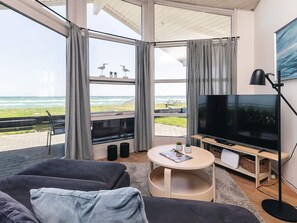 A modern living room with a large TV, comfortable seating, and a view of the ocean. - Luring Holiday Home in Poljana With Sea Nearby (Otterup)