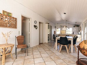 A spacious kitchen with a dining area, white brick walls, and a tiled floor. - 6 Person Holiday Home in Albaek (Aalbaek)