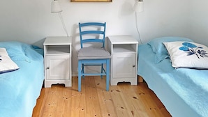 A bedroom with two beds, a desk, a chair, and a wall-mounted lamp. - Holiday Home in SÃ¶lvesborg (Sölvesborg)
