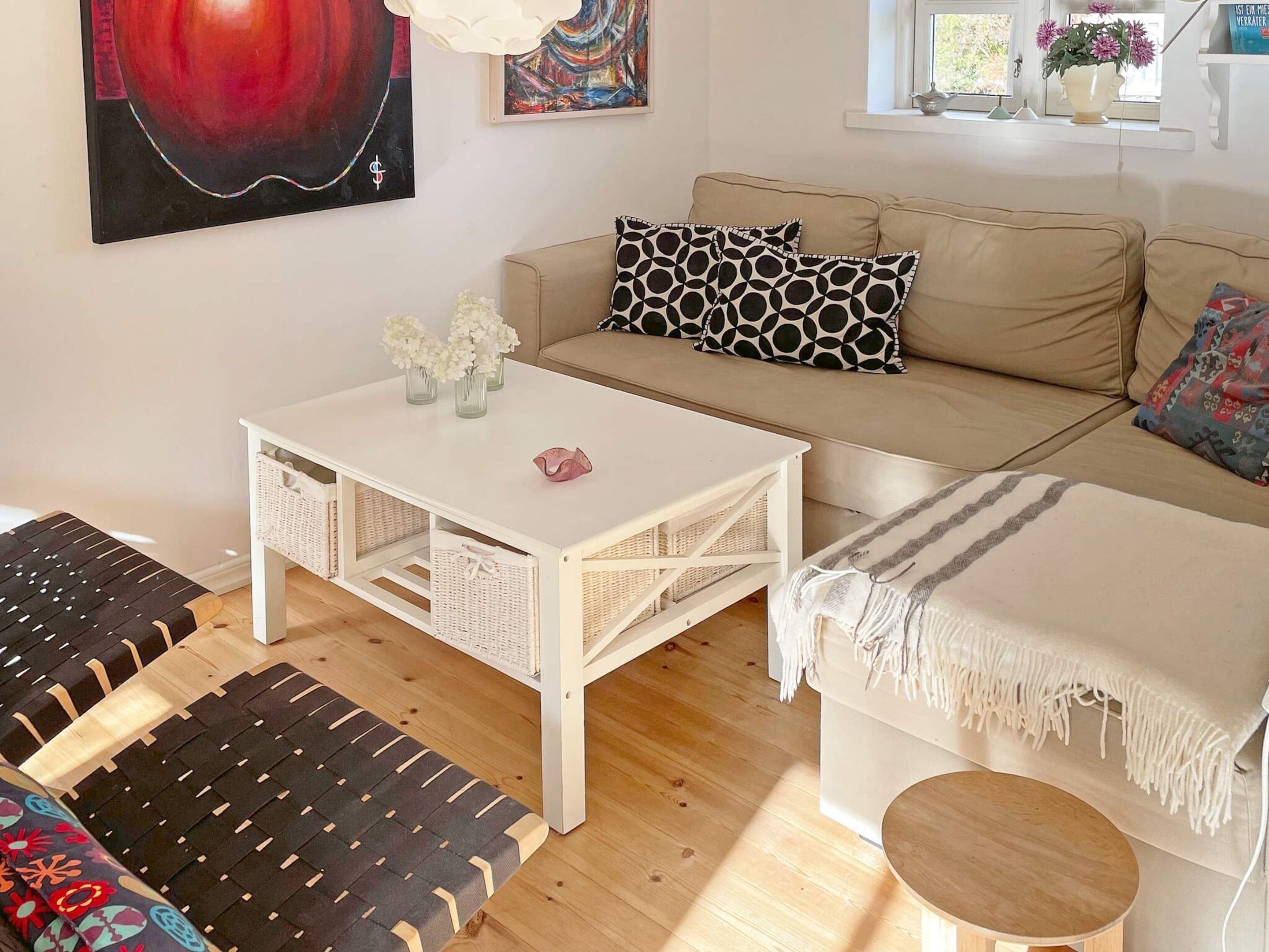 A living room with a sofa, a coffee table, a bench, and a round table.