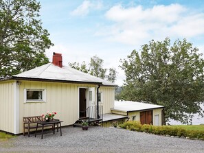 A small, single-story building with a sloped roof, a front door, and a small porch area.