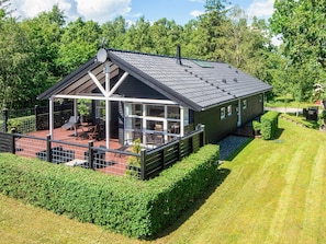 A modern house with a covered patio, a fenced garden, and a well-maintained lawn. - 5 Star Holiday Home in Hadsund (Hadsund)