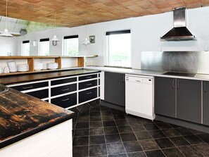 A modern kitchen with a black and white color scheme, a built-in dishwasher, and a brick ceiling. - 4 Star Holiday Home in Logstor (Logstor)