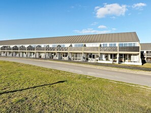 A motel with multiple rooms, a covered outdoor seating area, and a parking lot.