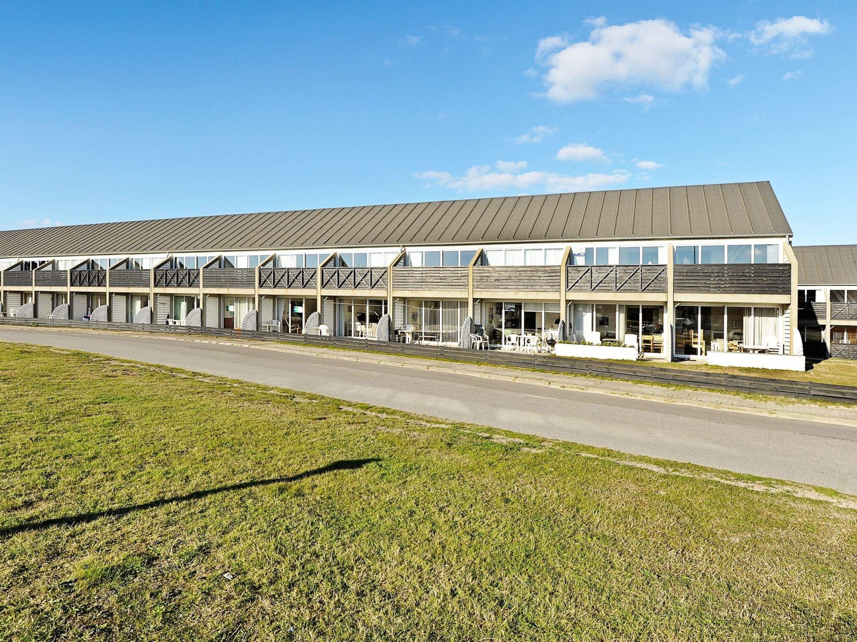 Un motel doté de nombreuses chambres, d’un espace extérieur abrité avec des sièges et d’un parking.