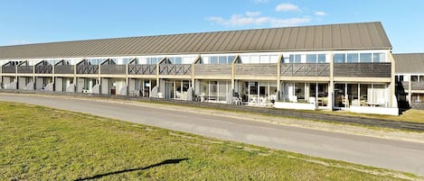 A motel with multiple rooms, a covered outdoor seating area, and a parking lot.