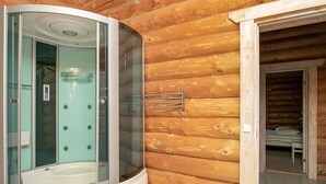 A modern bathroom with a glass-enclosed shower, a visible control panel, and a wooden cabin interior. - 5 Star Holiday Home in Frostrup (Frøstrup)