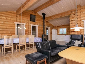 A log cabin interior with a dining area, a sofa, and a kitchen. - 5 Star Holiday Home in Frostrup (Frøstrup)