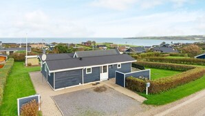 A residential property with a garage, a paved driveway, and a view of the sea. - 4 Star Holiday Home in Lemvig (Lemvig)