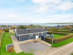Ein Wohnhaus mit Garage, befestigter Auffahrt und Meerblick.