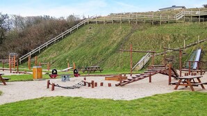 A playground with various equipment including slides, swings, and climbing structures.