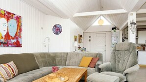 A living room with a grey sofa, a wooden coffee table, and a grey armchair. - 4 Star Holiday Home in Lemvig (Lemvig)