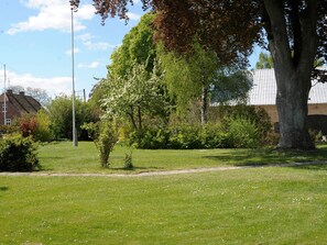 A grassy area with trees and a building in the background.