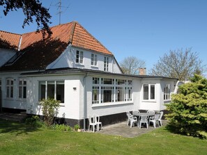 A two-story white building with a red-tiled roof, a patio with outdoor seating, and a number '306' sign. - Peaceful Holiday Home in Thisted near Sea (Nordborg)