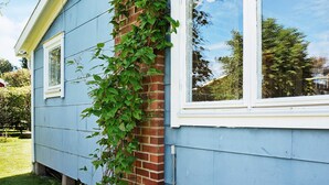A house with a blue exterior, a brick chimney, and a window with a white frame. - 6 Person Holiday Home in Falkenberg (Falkenberg)