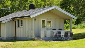 A small, single-story building with a porch and a table with chairs. - 4 Person Holiday Home in Utvik (Stryn)
