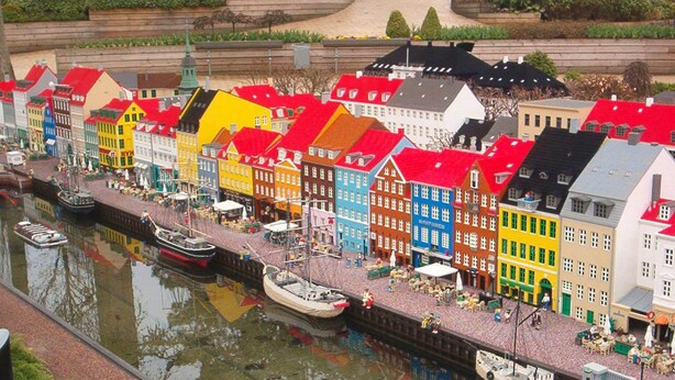 A model of a canal with colorful buildings and boats.