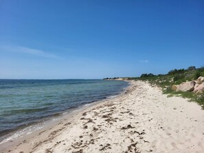 A beach with clear water, sandy shore, and rocky outcrops. - 5 Star Holiday Home in Sydals (Sydals)