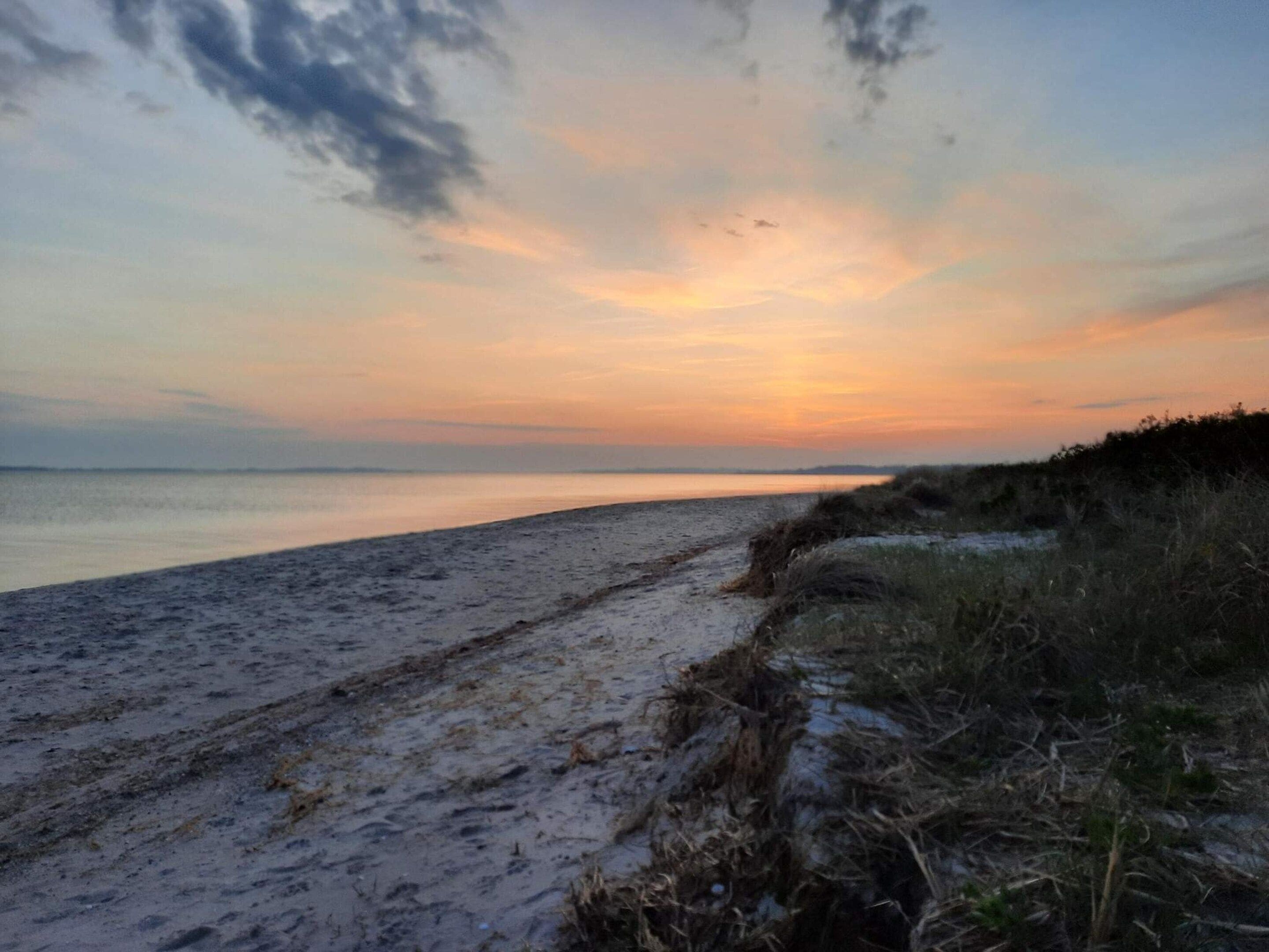 A beach with a clear sky and a sunset.