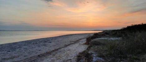 A beach with a clear sky and a sunset.