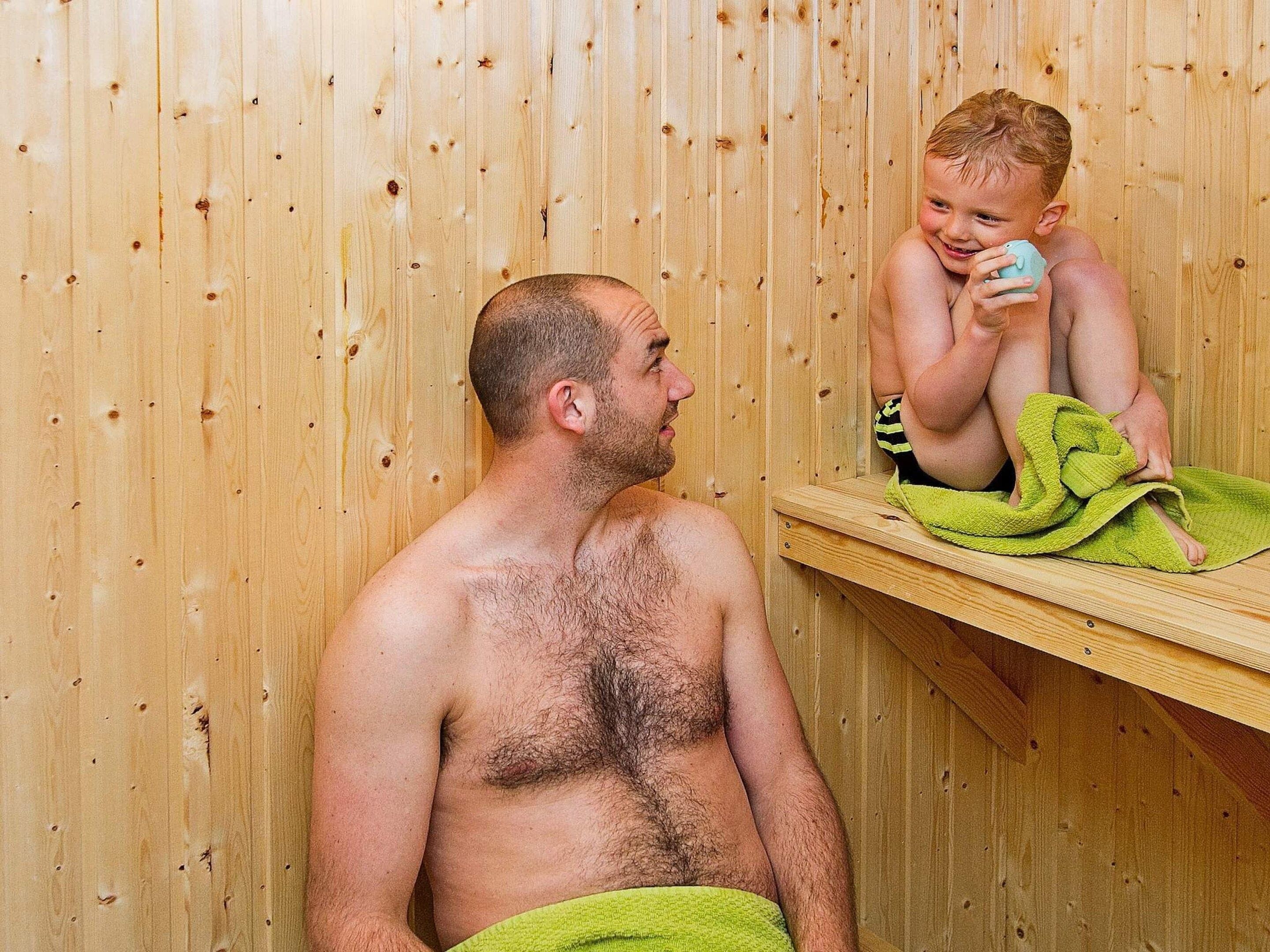 A wooden sauna with a bench and a towel.
