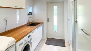 A compact kitchen with a washing machine, a sink, and a refrigerator. - Holiday Home in Stjärnhov (Stjarnhov)