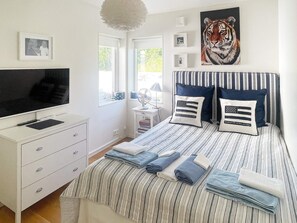 A bedroom with a bed, a TV, a dresser, and a window. - Holiday Home in Stjärnhov (Stjarnhov)