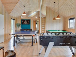 A spacious indoor area with a foosball table, ping pong table, dartboard, and wooden walls. - 5 Star Holiday Home in Sydals (Sydals)