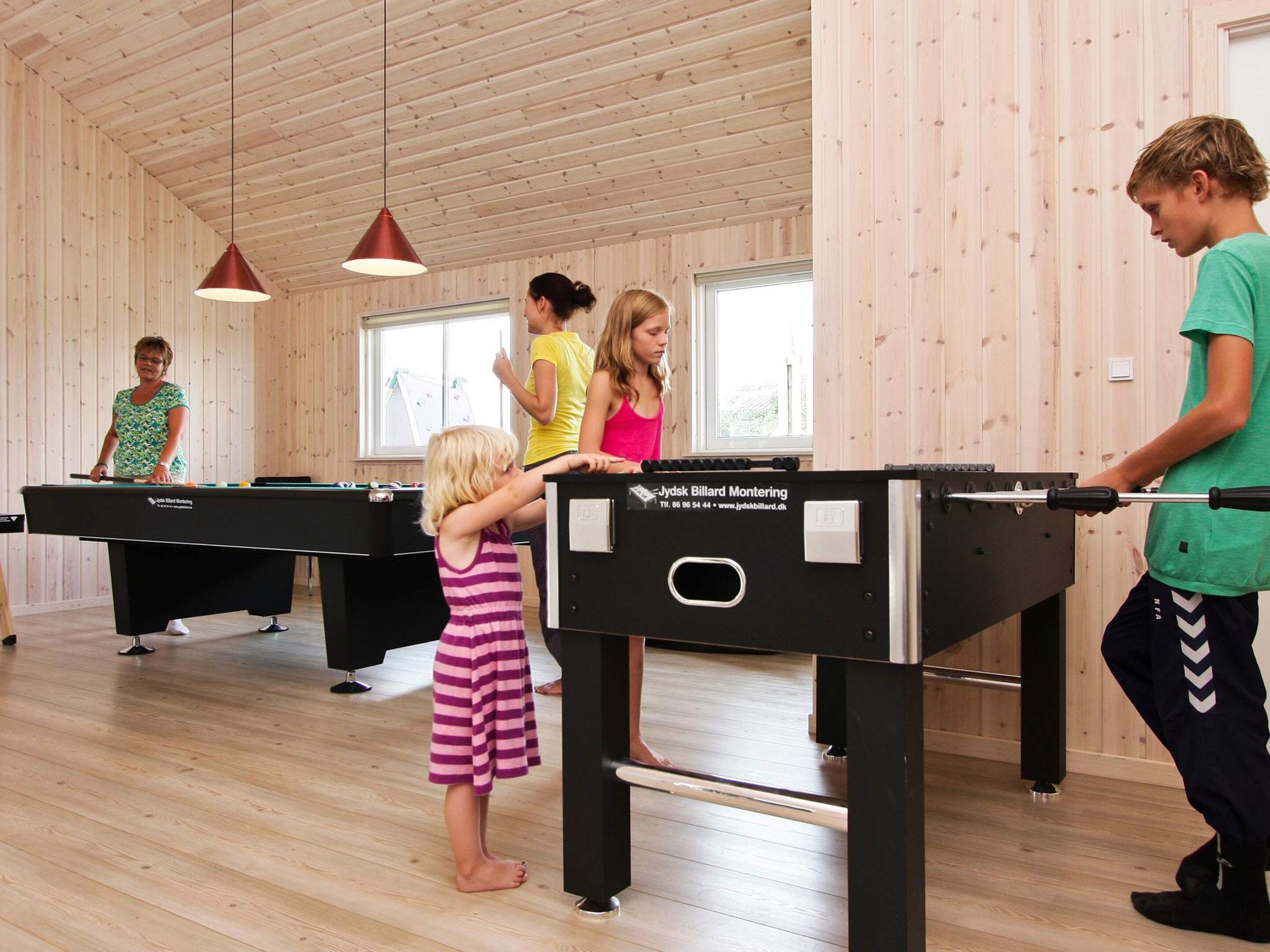 A pool table area with multiple tables and a person playing.