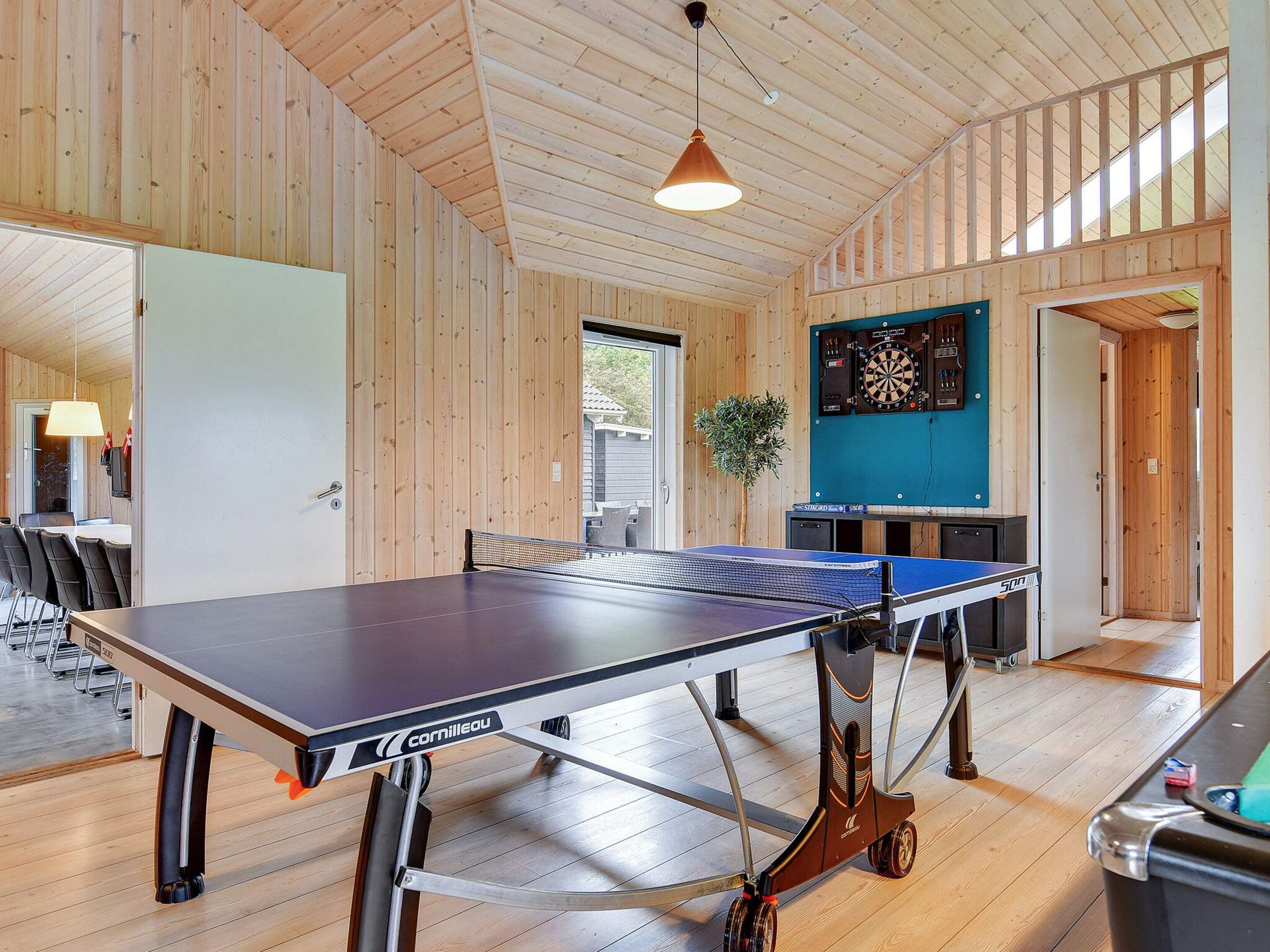 A ping pong table in a room with wooden walls and a ceiling.