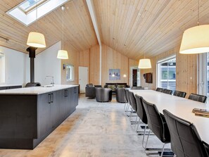 A modern kitchen with a central island, dining area with chairs, and a large window. - 5 Star Holiday Home in Sydals (Sydals)