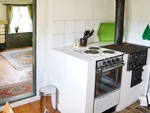 A compact kitchen with a gas stove, oven, and a green cutting board. - 4 Person Holiday Home in Ankarsrum (Ankarsrum)