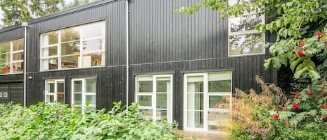 A modern two-story building with large windows and a wooden exterior.