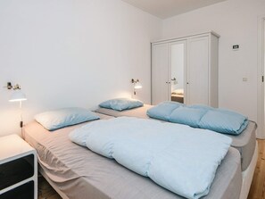A bedroom with two beds, a wardrobe, and bedside lamps. - Gorgeous Holiday Home in Ebeltoft with Hot Tub (Ebeltoft)