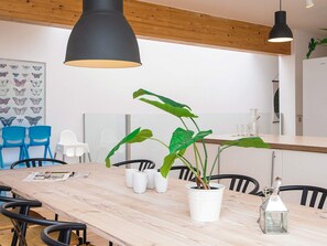A modern dining area with a wooden table, chairs, and a potted plant.
