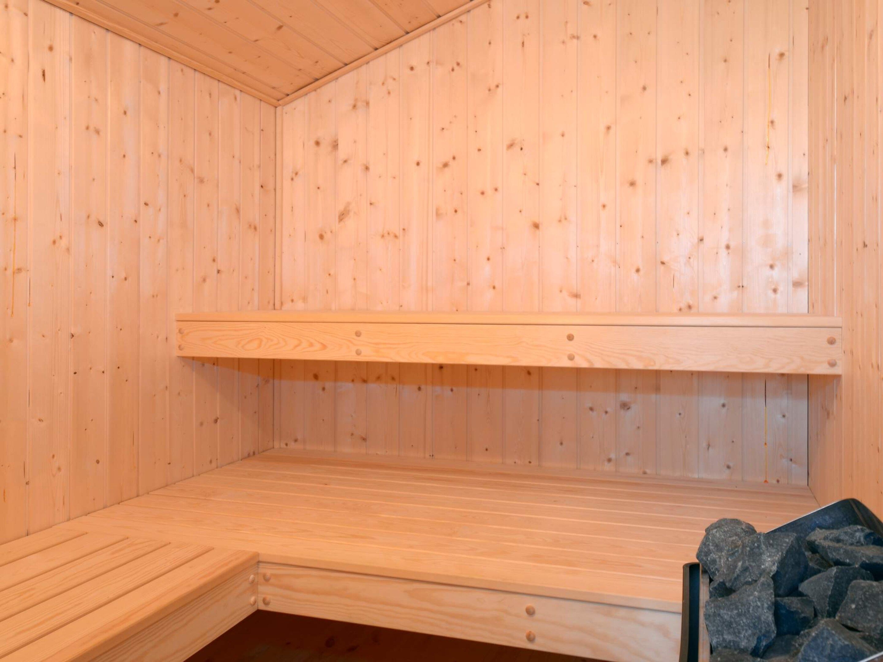 A sauna room with wooden walls and benches.