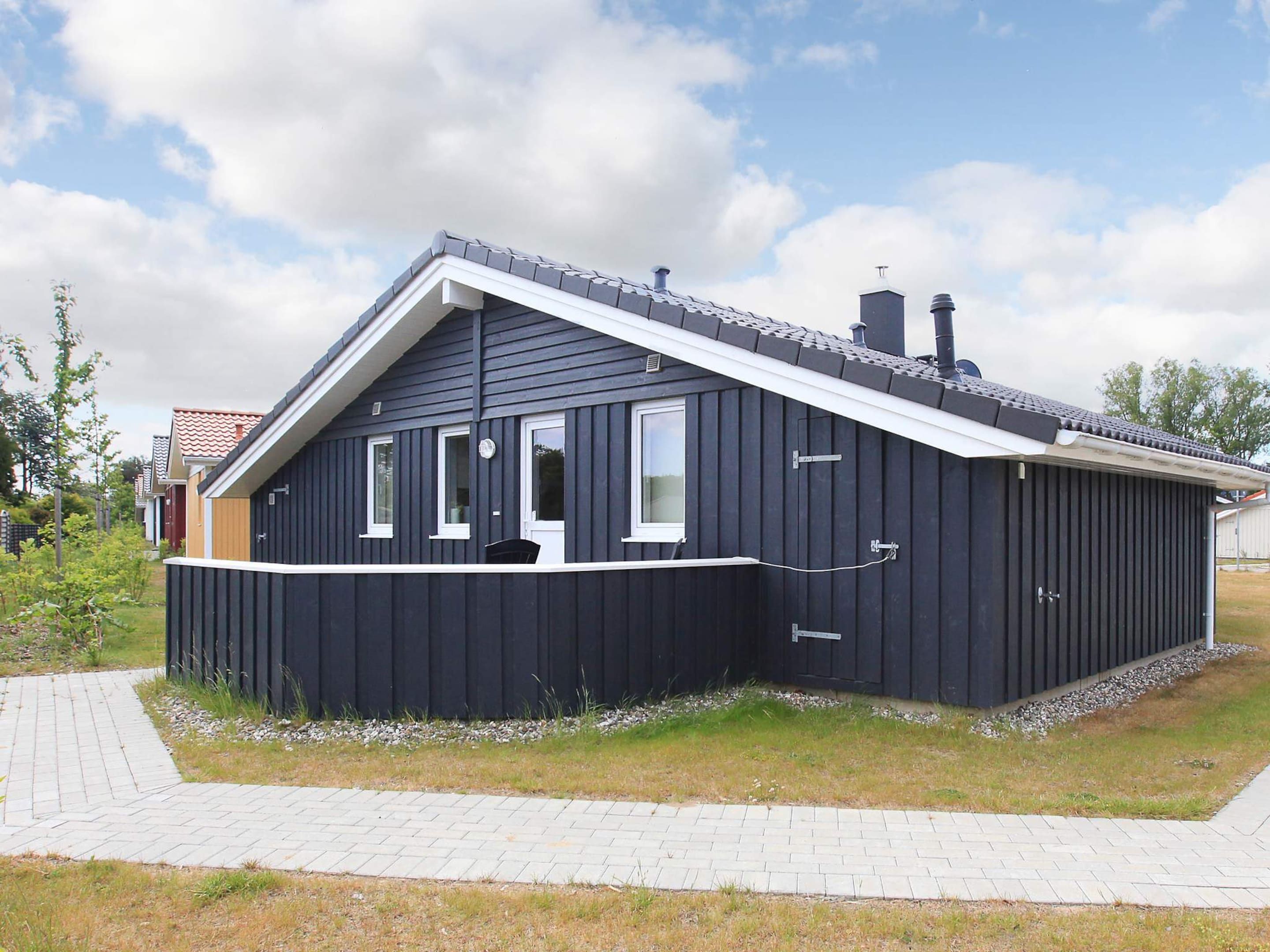 A single-story building with a dark exterior, a pitched roof, and a small porch area.