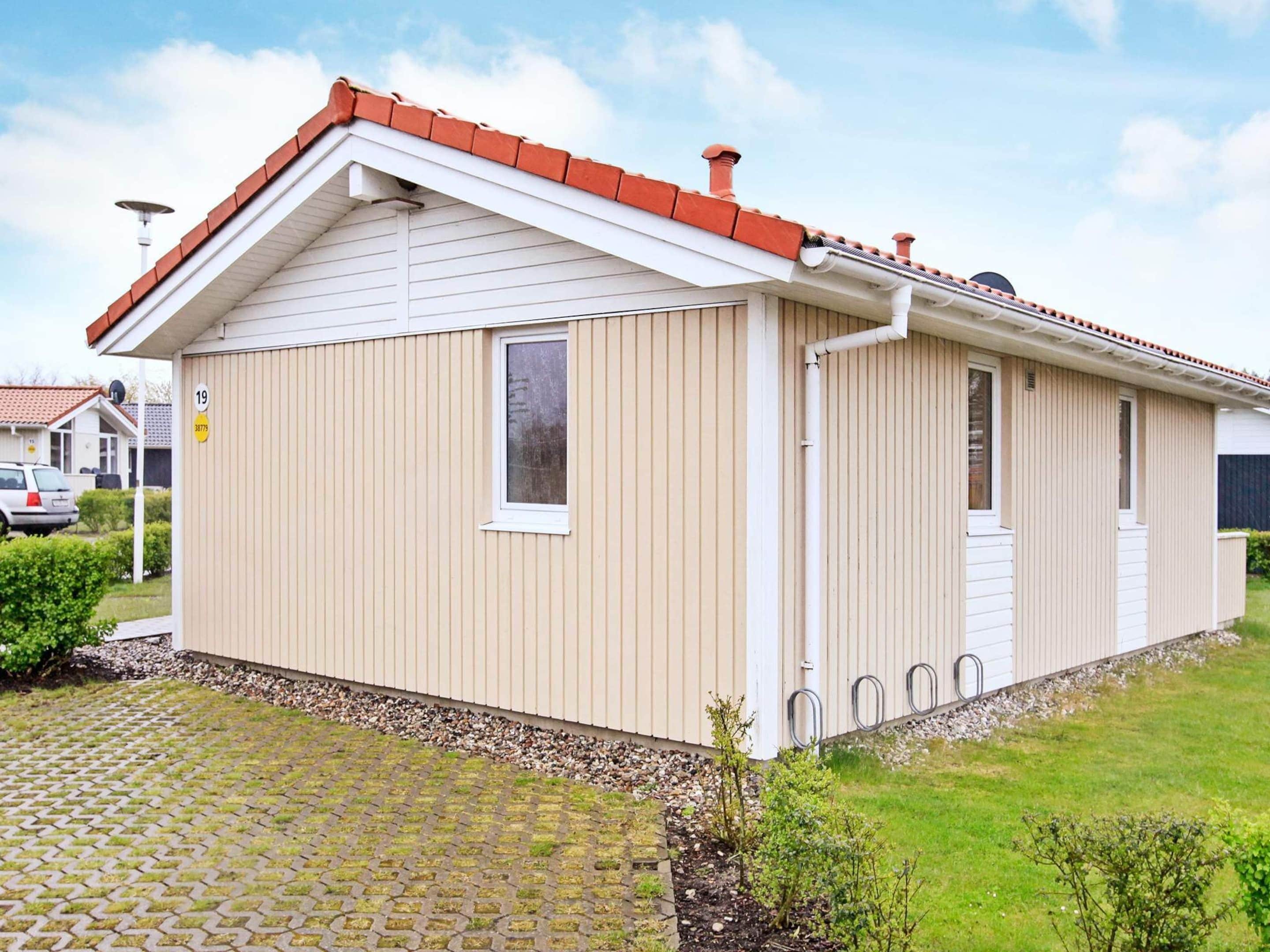 A single-story building with a pitched roof, a small window, and a door.