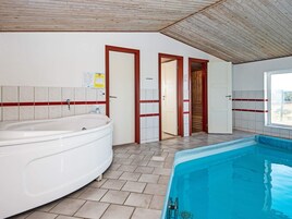A bathroom with a bathtub, a shower, and a window.
