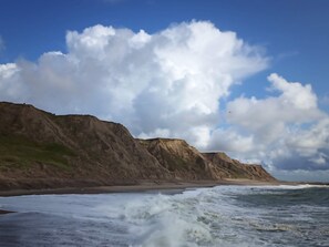 A coastal landscape with cliffs and waves.