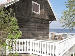 A wooden building with a white balcony and a view of the sea. - 6 Person Holiday Home in Hova (Hova)